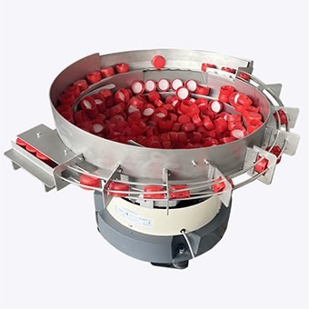 Plastic closures in a cap feeding bowl used to compare cap sorting technologies